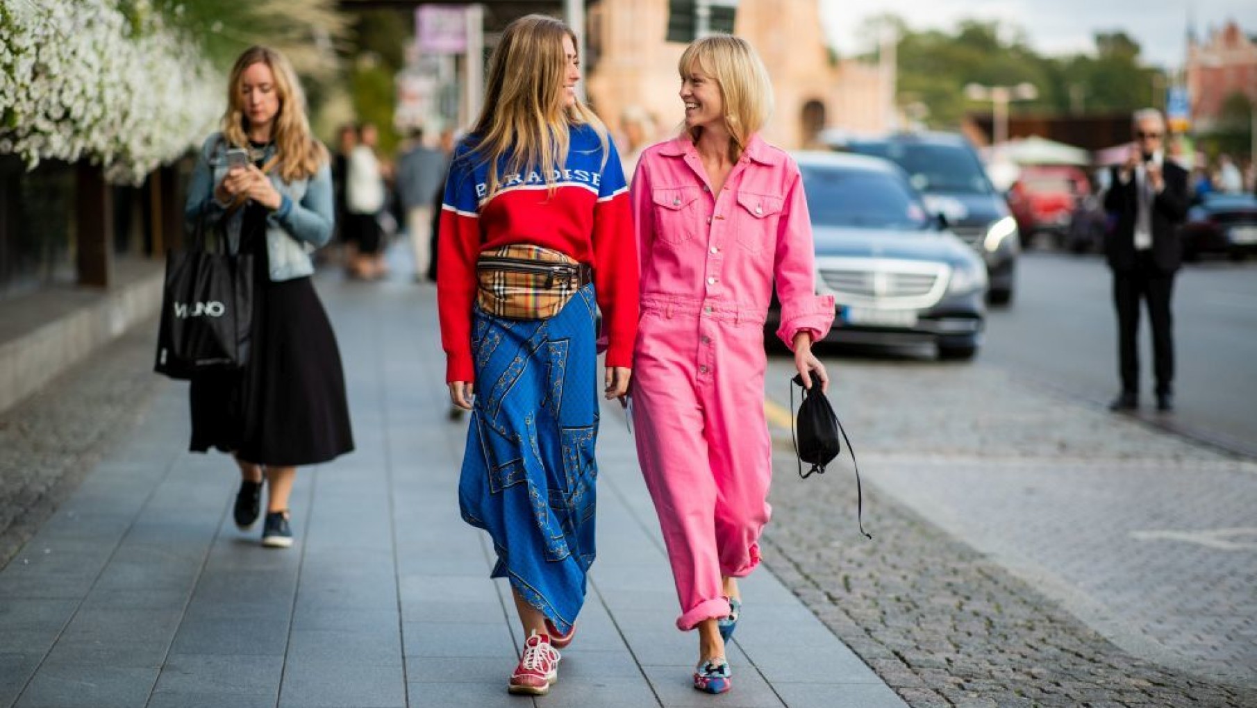 STOCKHOLM, SWEDEN – AUGUST 29: Emili Sindlev wearing Burberry fanny bag, blue red sweater with print Paradise, blue skirt and Jeannette Madsen wearing pink overall is seen during Stockholm Runway SS19 on August 29, 2018 in Stockholm, Sweden. (Photo